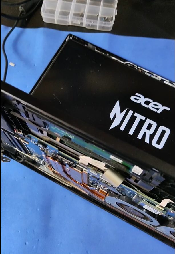 Notebook Acer Nitro aberto por baixo, com a placa e o cooler à mostra durante a manutenção