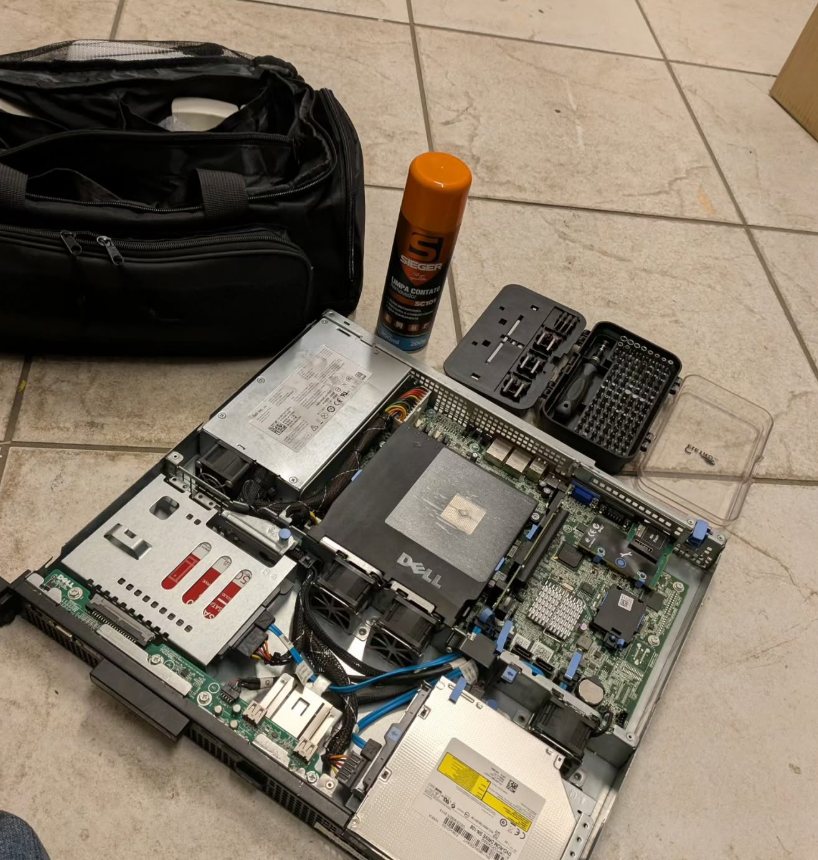 Servidor Dell aberto no chão para manutenção, ao lado da bolsa de ferramentas e do kit de chaves